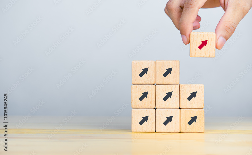 Businessman hand picked wooden block with red arrow. Individual and standing out from the crowd concept. Copy space Businessman hand picked wooden block with red arrow. Individual and standing out from the crowd concept. Copy space