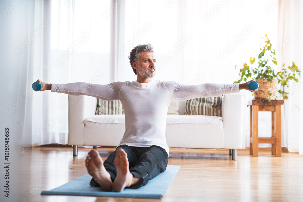 Handsome man exercising at home on gym mat. Routine home workout for a middle-aged man. Handsome man exercising at home on gym mat. Routine home workout for a middle-aged man.