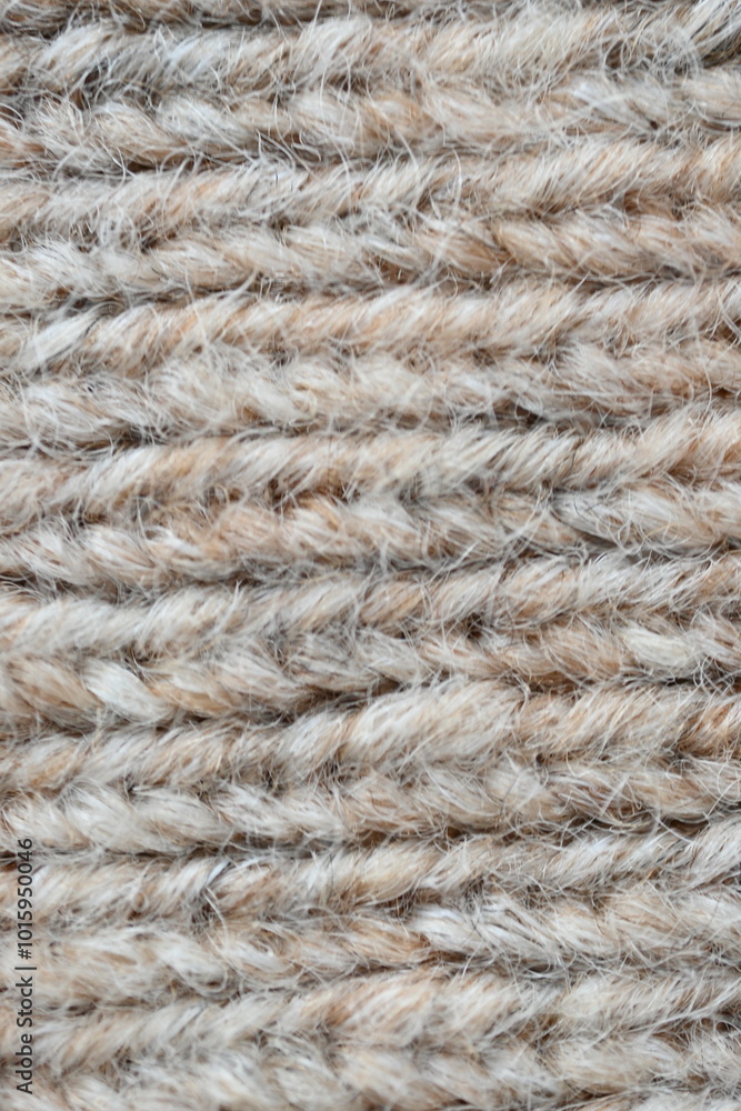 The texture of fabric thick beige sweater close-up. Knitted texture background The texture of fabric thick beige sweater close-up. Knitted texture background