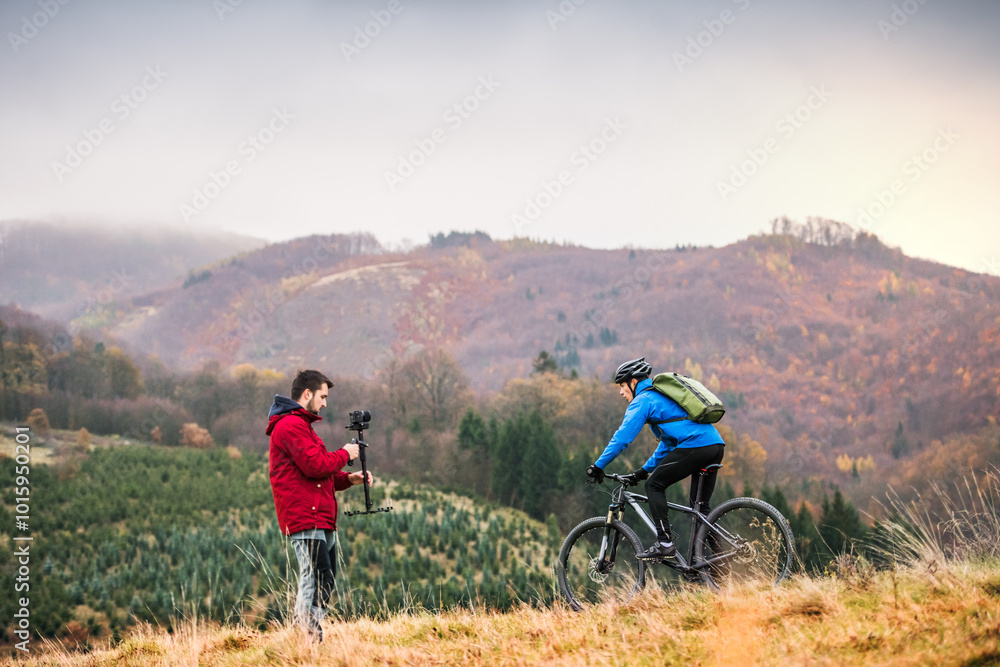 Cyclist is filming video, riding in nature and cameraman with a camera is capturing his adrenaline ride. Cyclist is filming video, riding in nature and cameraman with a camera is capturing his adrenaline ride.