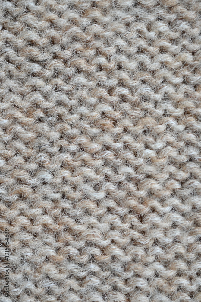 The texture of fabric thick beige sweater close-up. Knitted texture background The texture of fabric thick beige sweater close-up. Knitted texture background