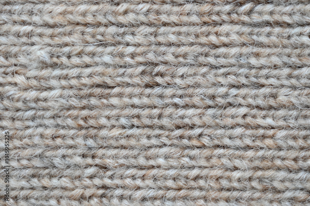 The texture of fabric thick beige sweater close-up. Knitted texture background The texture of fabric thick beige sweater close-up. Knitted texture background