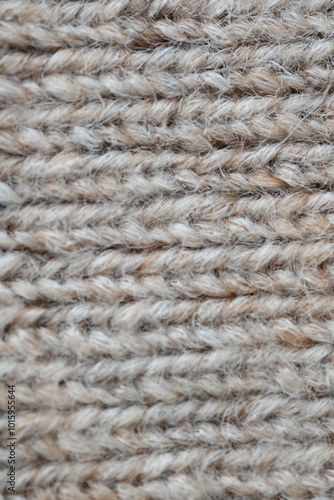 The texture of fabric thick beige sweater close-up. Knitted texture background