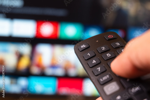 Tv online. Television streaming video. Media TV on demand. Online Multimedia video concept on TV set in dark room. Watching online TV with remote control in hand.