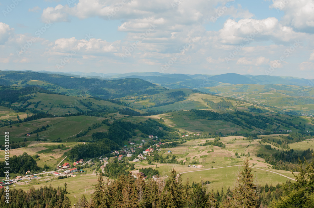 Naklejka premium Scenic Overlook of Rolling Hills and Lush Green Valleys Under a Bright Blue Sky