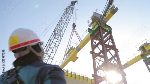 건설 현장에서 크레인 작업을 감독하는 건설 노동자