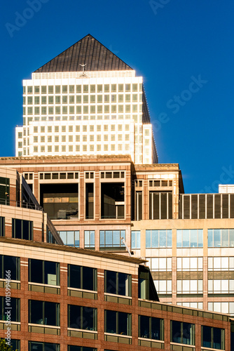 The pinnacle of a modern skyscraper gleams under the sun's bright light, showcasing its architectural prominence and the dynamism of contemporary urban landscapes in London UK