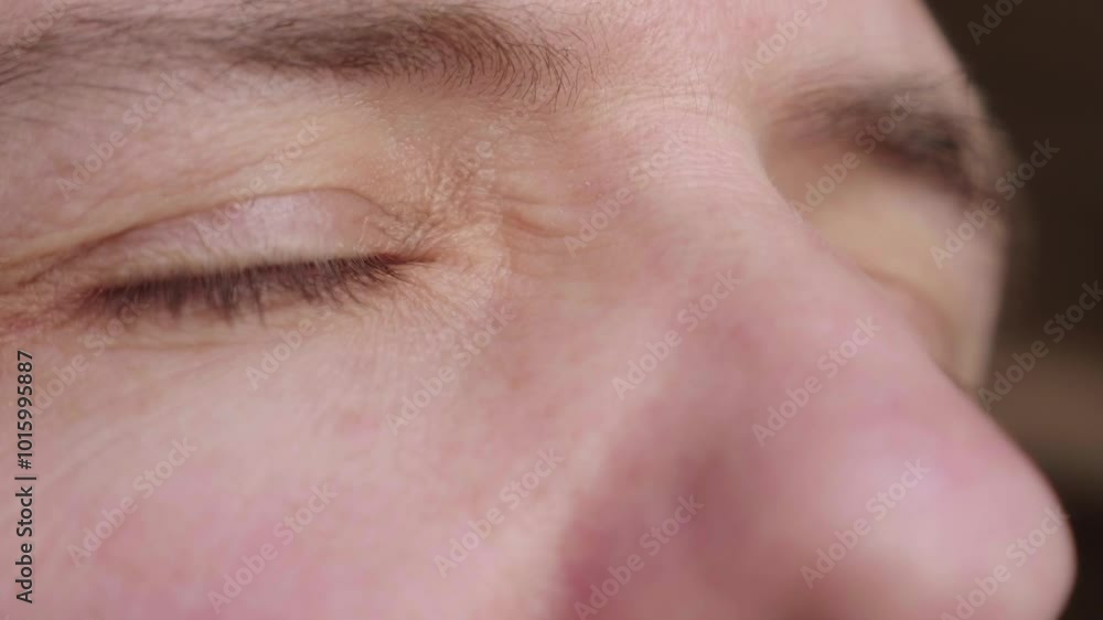 Close-up on the eyes of a mature man opening, looking to the side with a glimmer of hope for the future. His eyes are filled with optimism. Close-up on the eyes of a mature man opening, looking to the side with a glimmer of hope for the future. His eyes are filled with optimism.