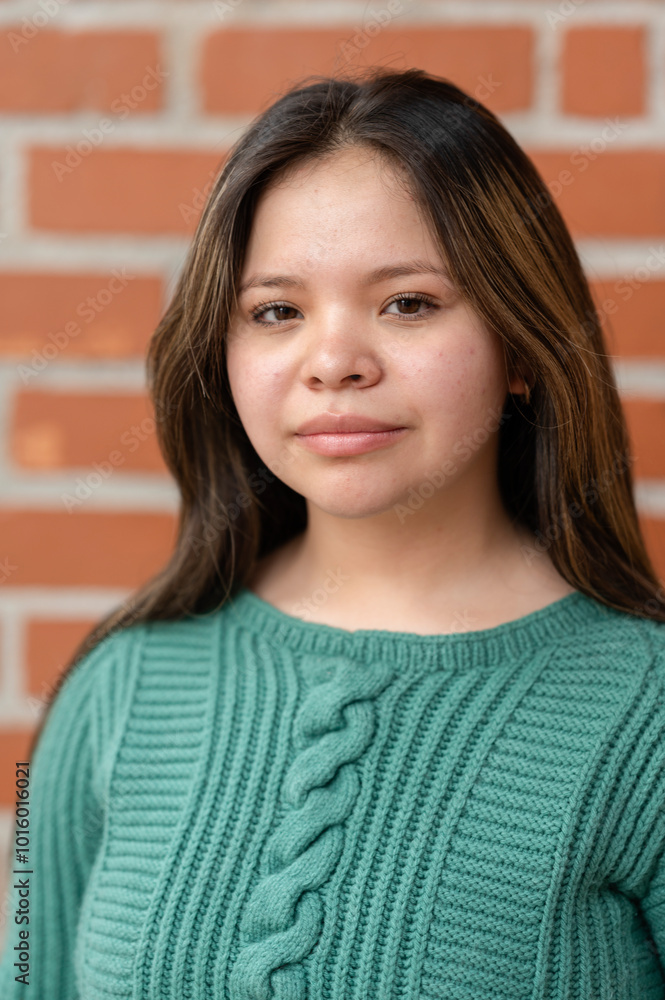 Portrait of young Latin American woman in front of brick wall Portrait of young Latin American woman in front of brick wall