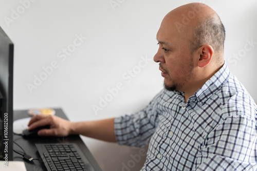 Latin man using computer at work photo