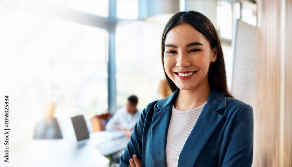 Fototapeta premium businesswoman in a modern office setting. She is smiling, dressed in professional attire, and standing with arms crossed, conveying leadership and professionalism, creative office space