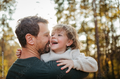 Father and girl during walk in autumn forest. Dad and girl having fun outdoors. photo