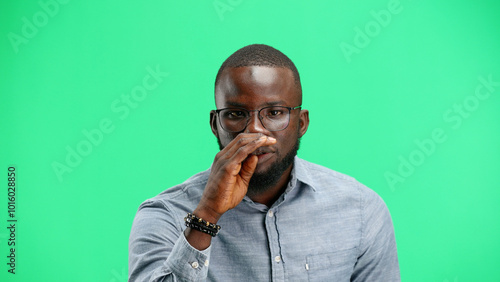 A man, close-up, on a green background, tells a secret