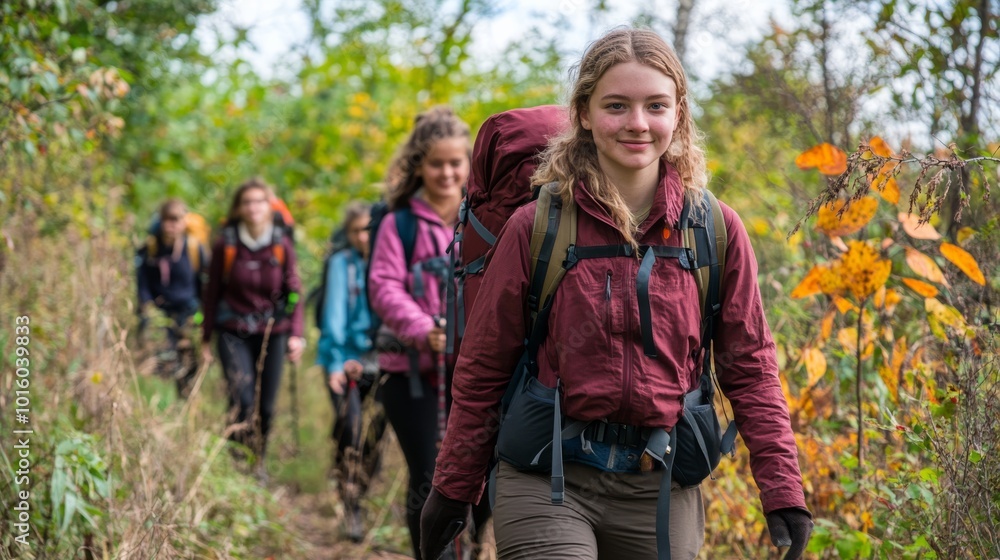A group of young hikers walking on a forest trail surrounded by greenery, enjoying nature and the outdoors. A group of young hikers walking on a forest trail surrounded by greenery, enjoying nature and the outdoors.