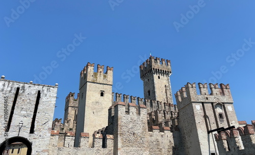 Vászonkép A panorama of the strong adamant towers of the medieval Scaliger castle in Sirmione against a clear blue summer sky