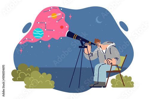 Man amateur astronomer uses telescope looking at stars and planets, sitting on chair in open air