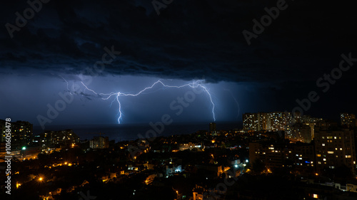 Nighttime Thunderstorm over a Seaside City