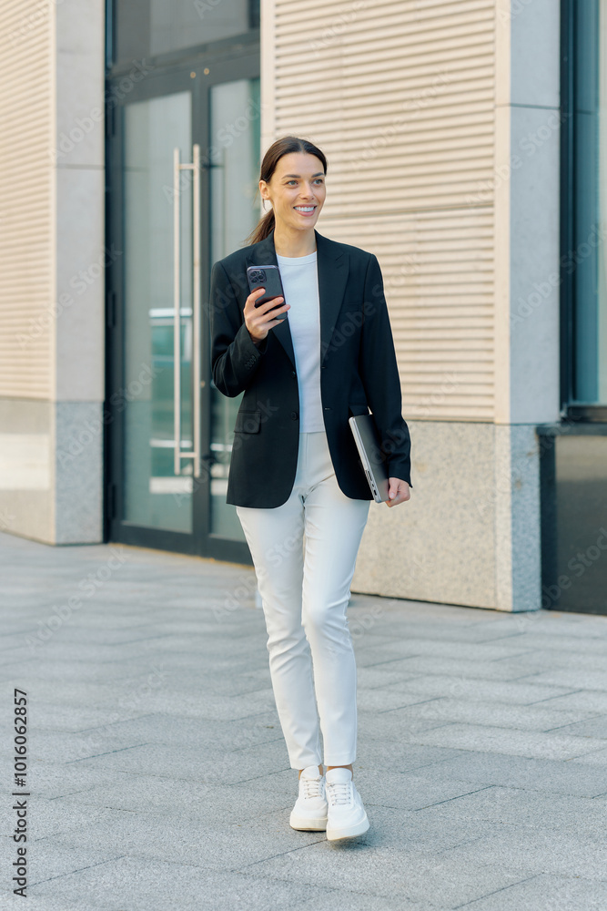 Pretty young business lady dressed in a jacket is hurrying to a meeting, full-length photo in motion Pretty young business lady dressed in a jacket is hurrying to a meeting, full-length photo in motion