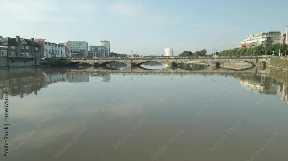 A peaceful morning view of the Shannon River reflecting Limerick City’s skyline and historic bridge A peaceful morning view of the Shannon River reflecting Limerick City’s skyline and historic bridge