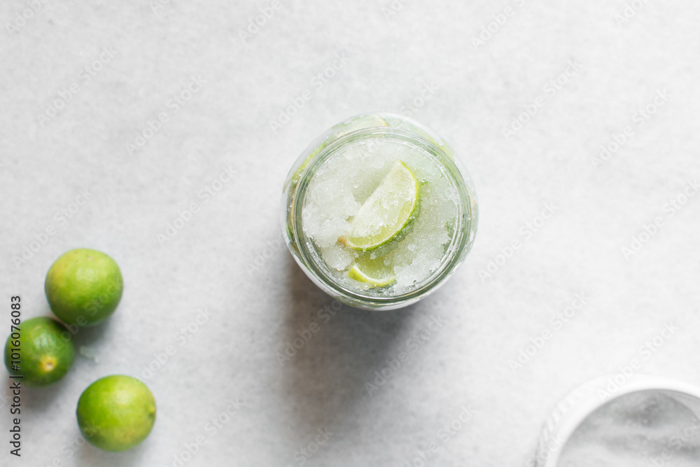 Overhead view of Lime cheong in a glass jar on a white background, top view of korean lime cheong in a transparent jar, limes in sugar syrup, process of making lime cheong Overhead view of Lime cheong in a glass jar on a white background, top view of korean lime cheong in a transparent jar, limes in sugar syrup, process of making lime cheong