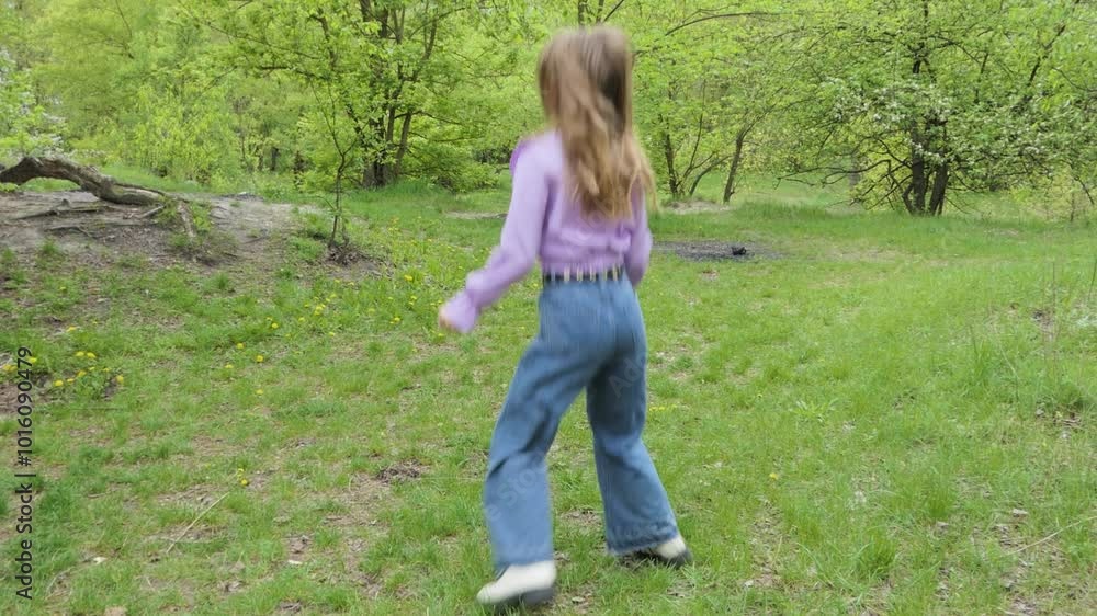 The girl is actively jumping in her boots on the grass. The girl is actively jumping in her boots on the grass.