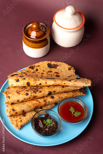 Healthy Indian Mooli or Radish paratha or stuffed flatbread with coriander and green chilli chutney on wooden background photo