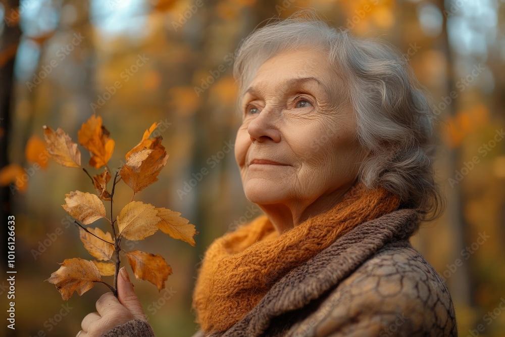 An elderly woman peacefully looks into the autumn distance while holding a small branch with yellow leaves, capturing a serene and introspective moment. An elderly woman peacefully looks into the autumn distance while holding a small branch with yellow leaves, capturing a serene and introspective moment.