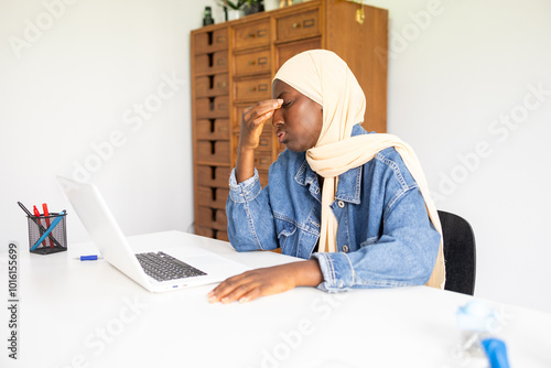 Black female doctor wearing hijab feeling stressed at work