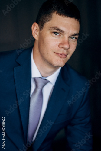 portrait of groom in blue three piece suit with tie on wedding day