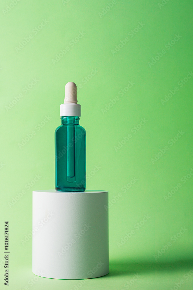 Fototapeta premium Blue sunscreen bottle on green background. Sunscreen concept. Skin care concept. Copy space.