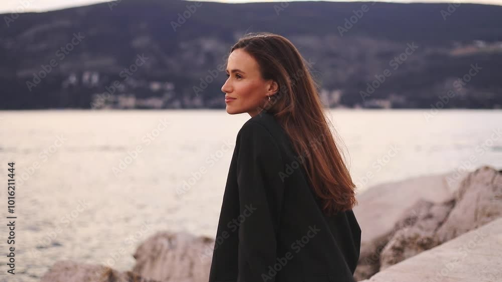 Girl sitting and enjoying of sunset, sea and mountains. Business woman in jacket deep breathe of fresh air. Happy smiling woman have a good relax time. Turn head to camera, laughing, fix hair. Girl sitting and enjoying of sunset, sea and mountains. Business woman in jacket deep breathe of fresh air. Happy smiling woman have a good relax time. Turn head to camera, laughing, fix hair.