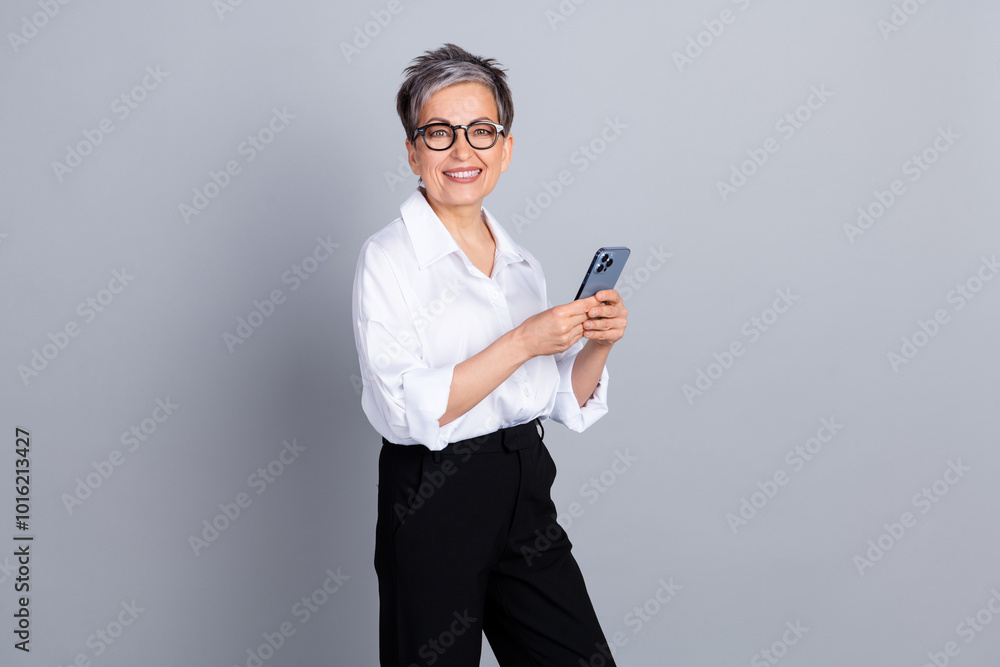 Photo portrait of lovely senior lady hold telephone dressed stylish formalwear isolated on gray color background Photo portrait of lovely senior lady hold telephone dressed stylish formalwear isolated on gray color background