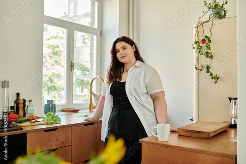 A confident woman relaxes at home, savoring her peaceful kitchen morning.