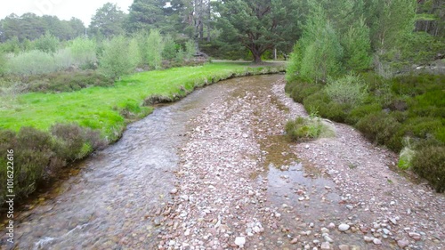 Wide river flowing through a park, following the flow of water photo