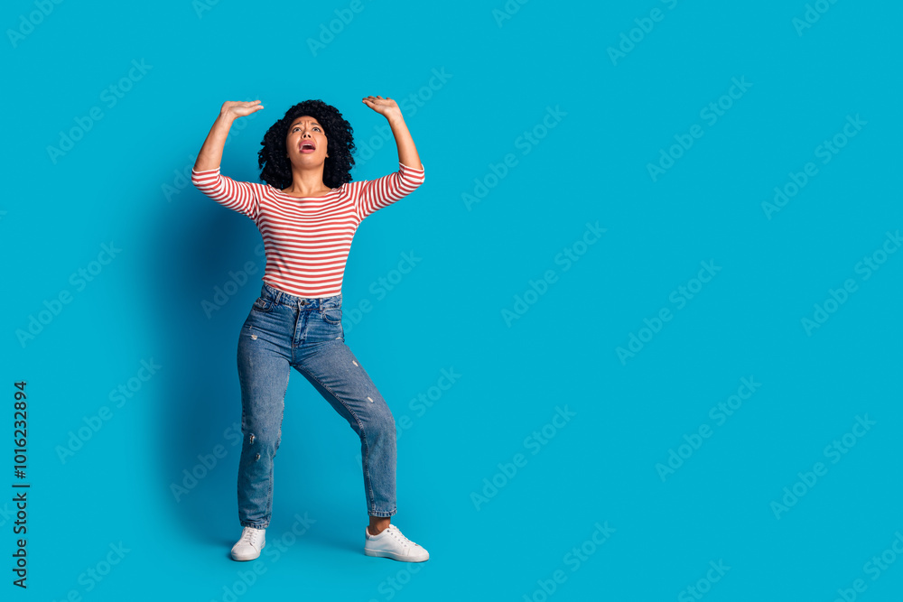 Photo of charming tired girl wear stylish clothes hand above head hold empty space poster isolated on blue color background Photo of charming tired girl wear stylish clothes hand above head hold empty space poster isolated on blue color background
