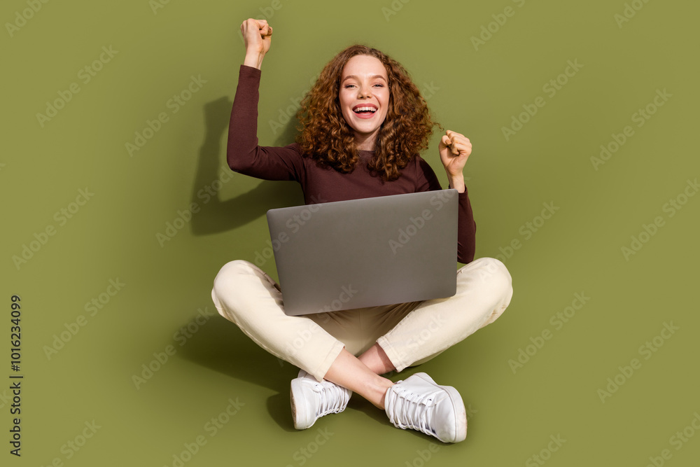 Full length photo of lucky attractive young lady dressed brown outfit winning game modern device empty space isolated khaki color background Full length photo of lucky attractive young lady dressed brown outfit winning game modern device empty space isolated khaki color background