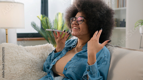 Bilde på lerret Ethnic girl African American woman talk virtual assistant on mobile phone smilin