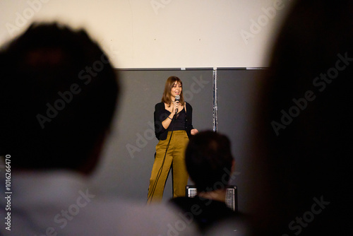 Female performer delivering a monologue on stage in an alternative theater with audience photo