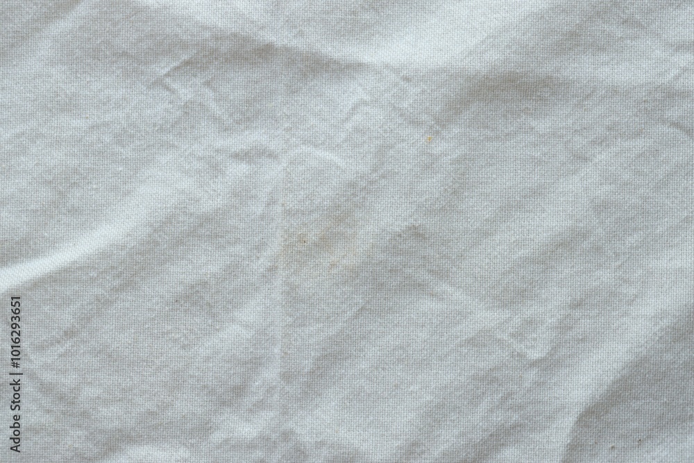 Naklejka premium Grey textile napkin in white color as background. Folded decorative kitchen cotton towel