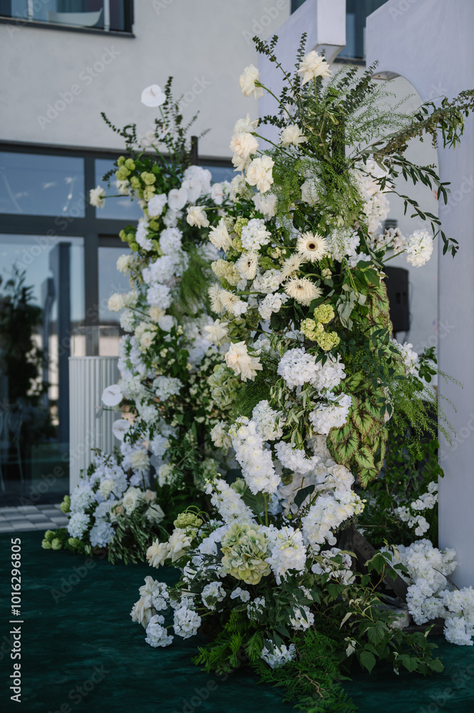 Naklejka premium Decor details closeup. Location for luxury wedding ceremony. Arch decorated white flowers, greens, greenery. Trendy decor in backyard. Celebration baptism concept. Birthday party reception.