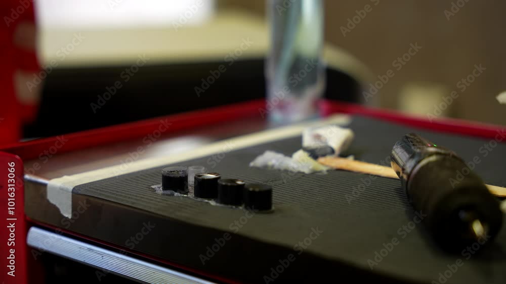 Tattoo artist taking some ink of a small pot from a work table with a pen for tattooing. Close up Tattoo artist taking some ink of a small pot from a work table with a pen for tattooing. Close up