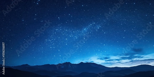 A stunning night sky filled with stars over a tranquil mountain landscape under a deep blue hue.