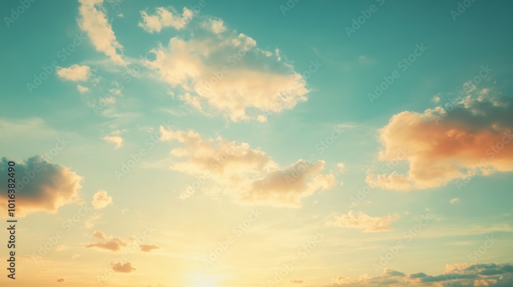 Obraz premium Golden-tinged Clouds in a Pale Blue Sky at Sunset