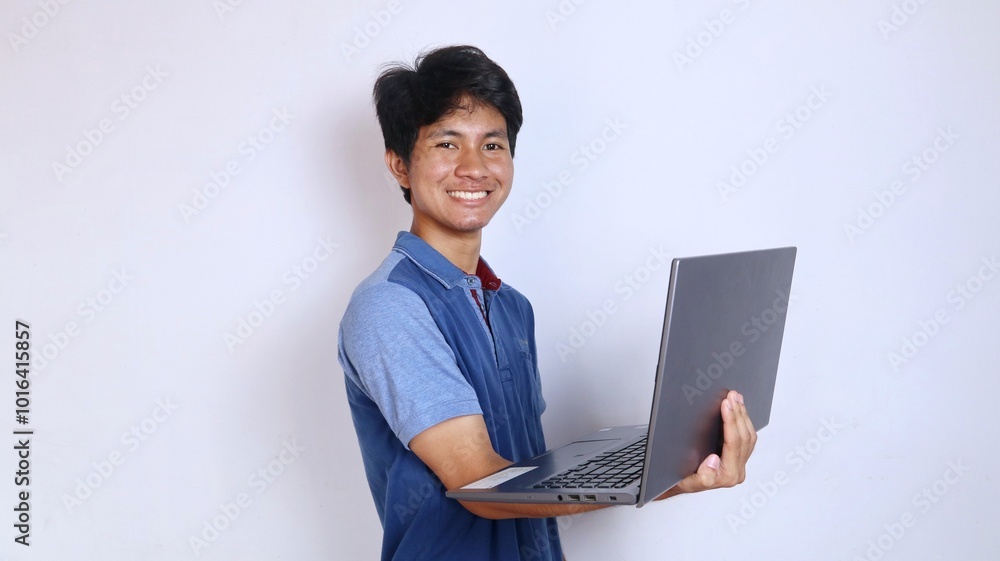 Asian young man smiling gesture holding laptop Asian young man smiling gesture holding laptop