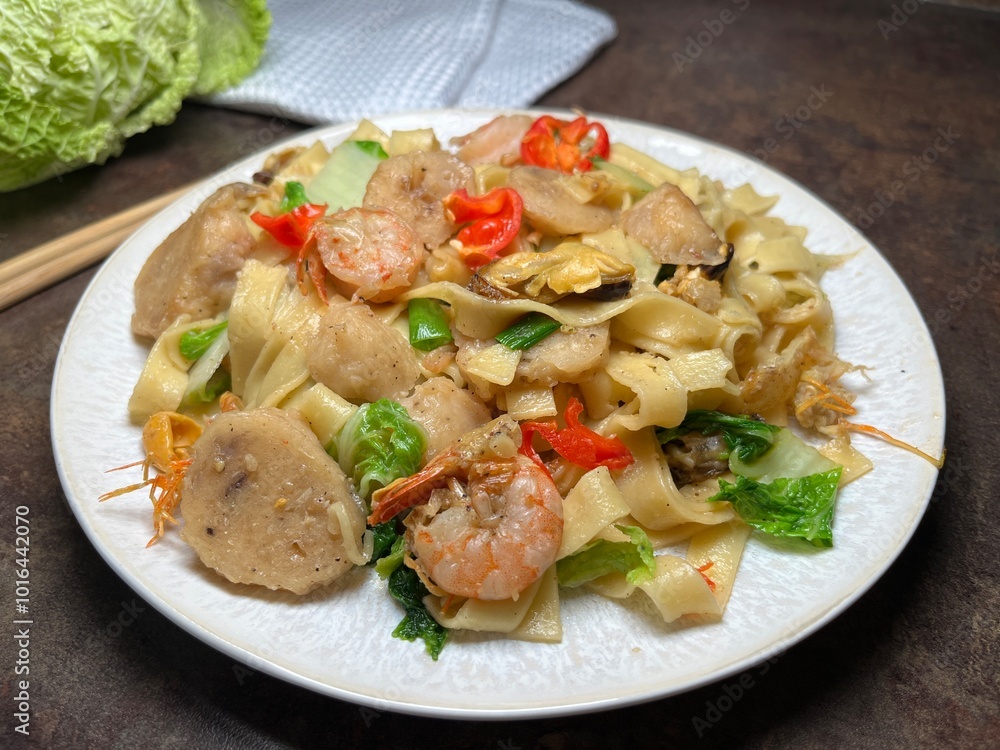 Spicy fried noodle with shrimp, chicken meat ball and vegetables. Thai style food. Spicy fried noodle with shrimp, chicken meat ball and vegetables. Thai style food.