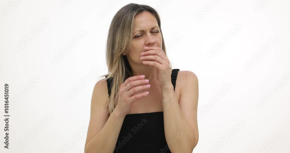 Woman overhears surprising gossip and widens eyes in shock on white background. Blonde lady covers mouth instinctively with hand slow motion