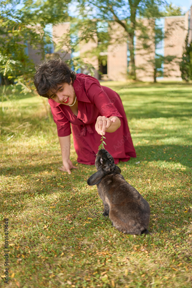 a young plus-size woman plays with her pet rabbits in the garden of a student dormitory a young plus-size woman plays with her pet rabbits in the garden of a student dormitory