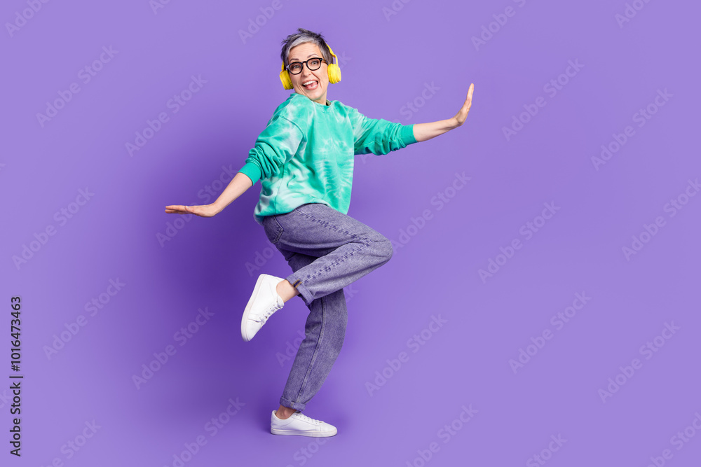 Obraz premium Full size photo of pretty retired female earphones dance have fun wear trendy green outfit isolated on violet color background