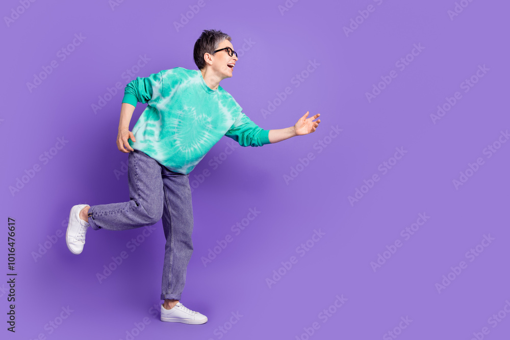 Full size photo of pretty retired female running black friday wear trendy green outfit isolated on violet color background Full size photo of pretty retired female running black friday wear trendy green outfit isolated on violet color background