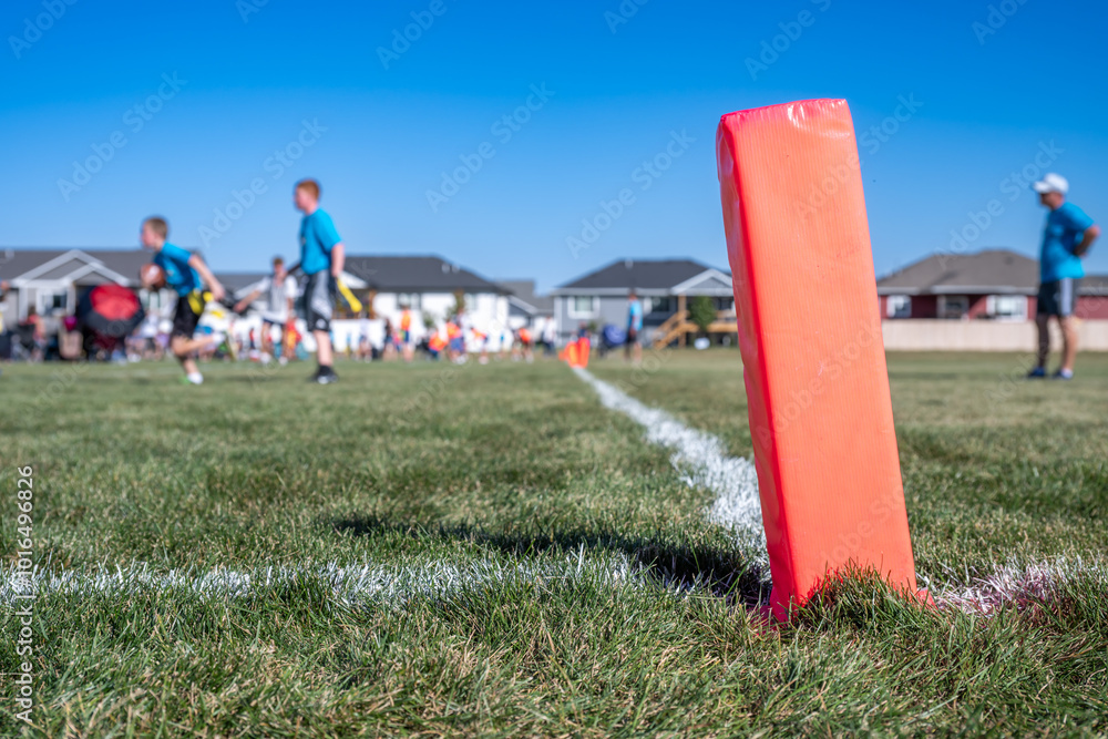 Selective focus on a pylon with a defocused flag football game in the background Selective focus on a pylon with a defocused flag football game in the background